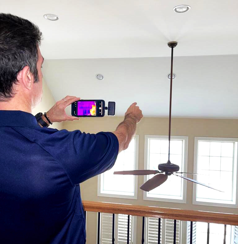 Inspector Ali Nakhaie using a thermal imagining scanner during a home inspection 